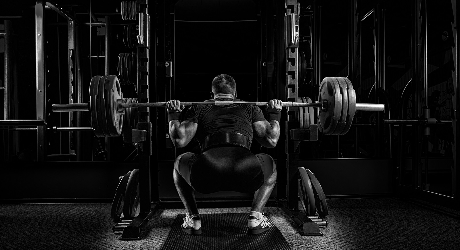 Man weightlifting - squat, deadlift, bench press. Push, pull, legs - the best fitness program for beginners who want to increase muscle mass